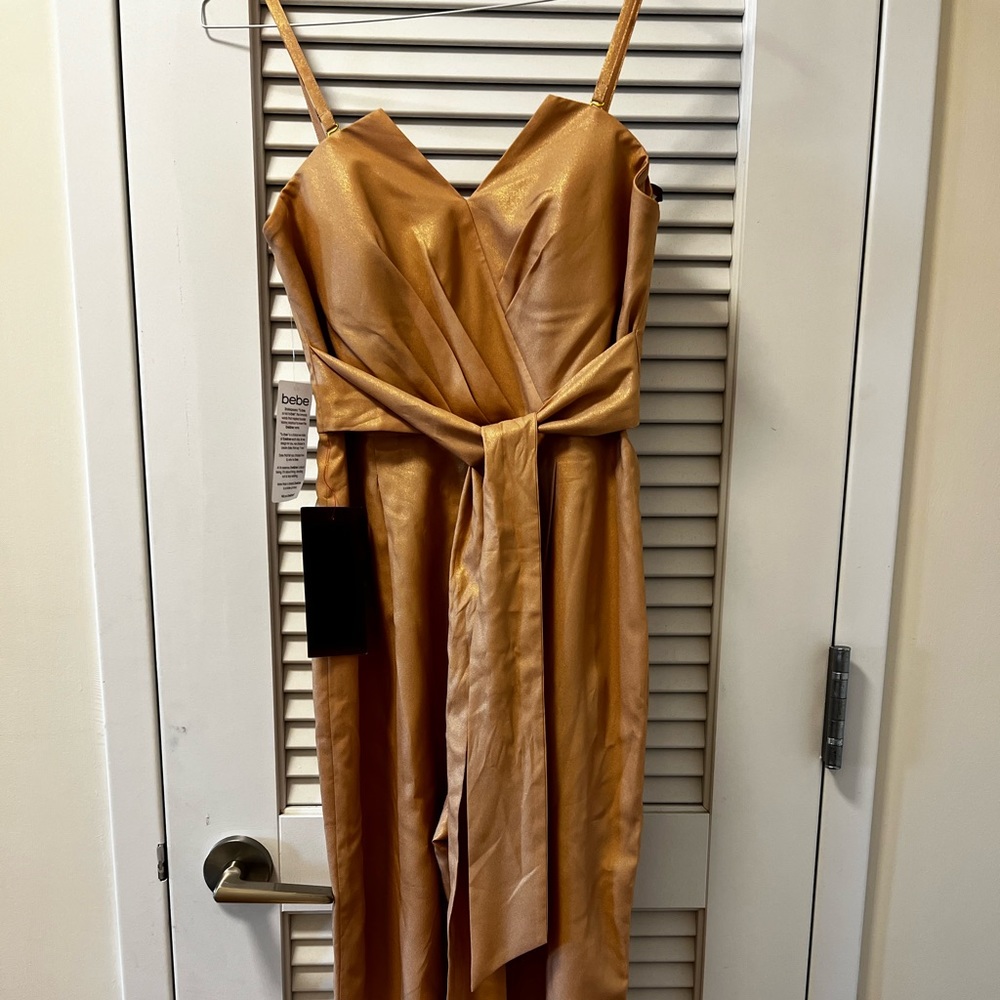 Bebe jumpsuit . Shiny material. Champagne color . Never worn .